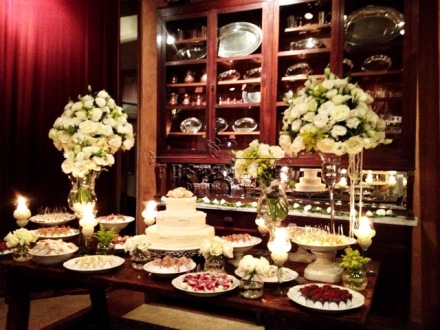 Mesa do bolo com velas e flores brancas
